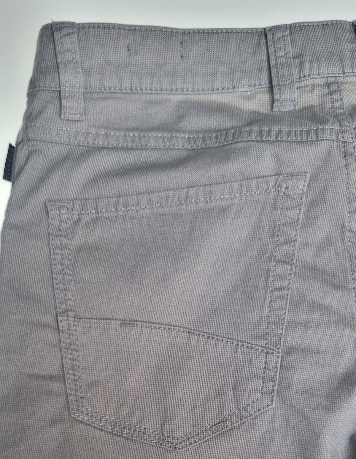Close-up of gray pants with a pocket on a light gray background