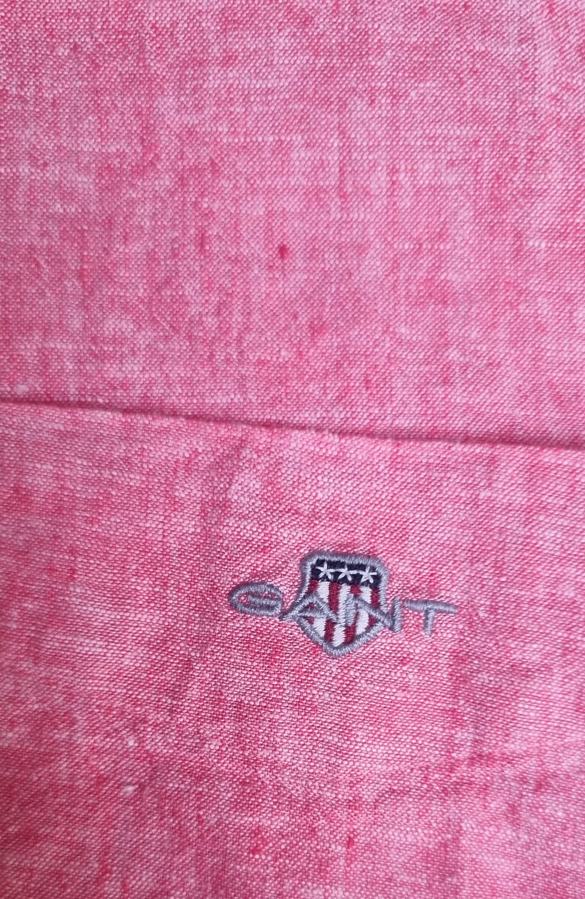 Close-up of a pink fabric with a logo in the center