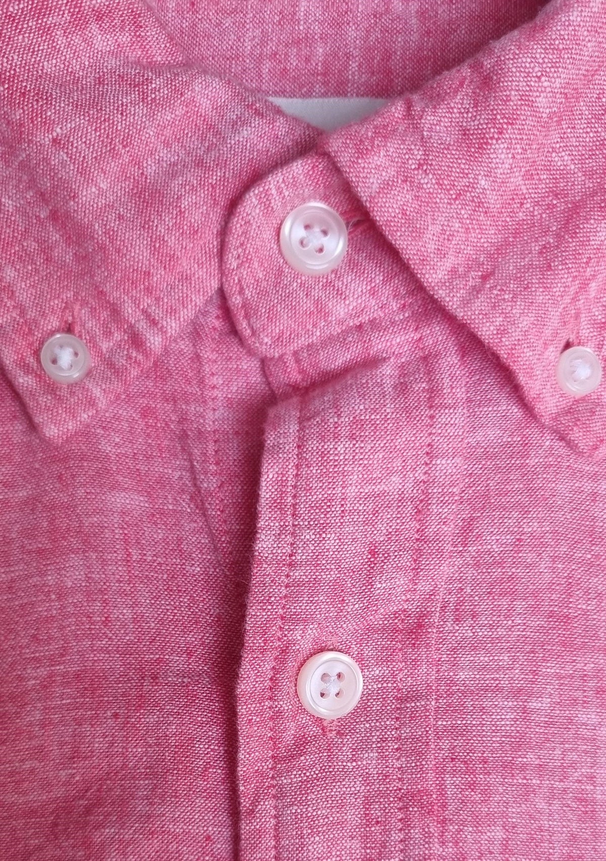 Close-up of a pink textured fabric with buttons