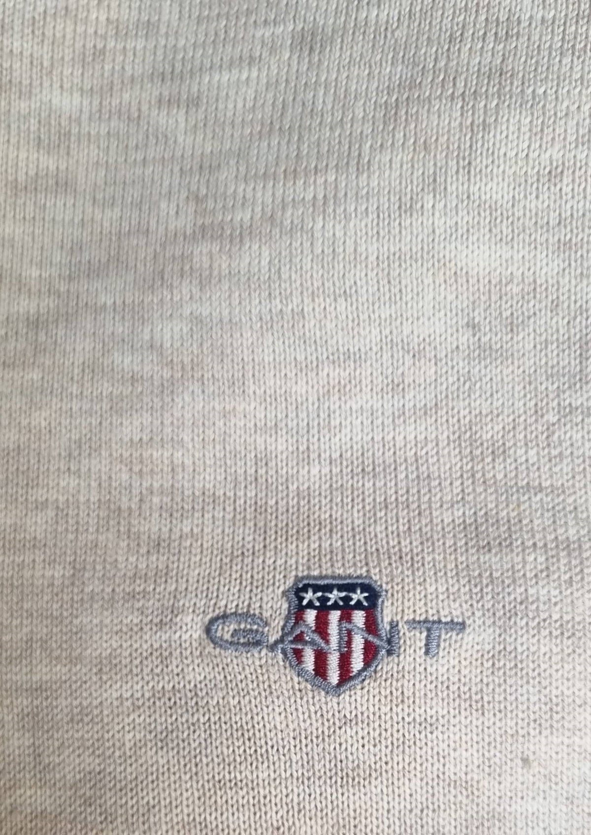 Close-up of a Gant logo on a gray fabric background