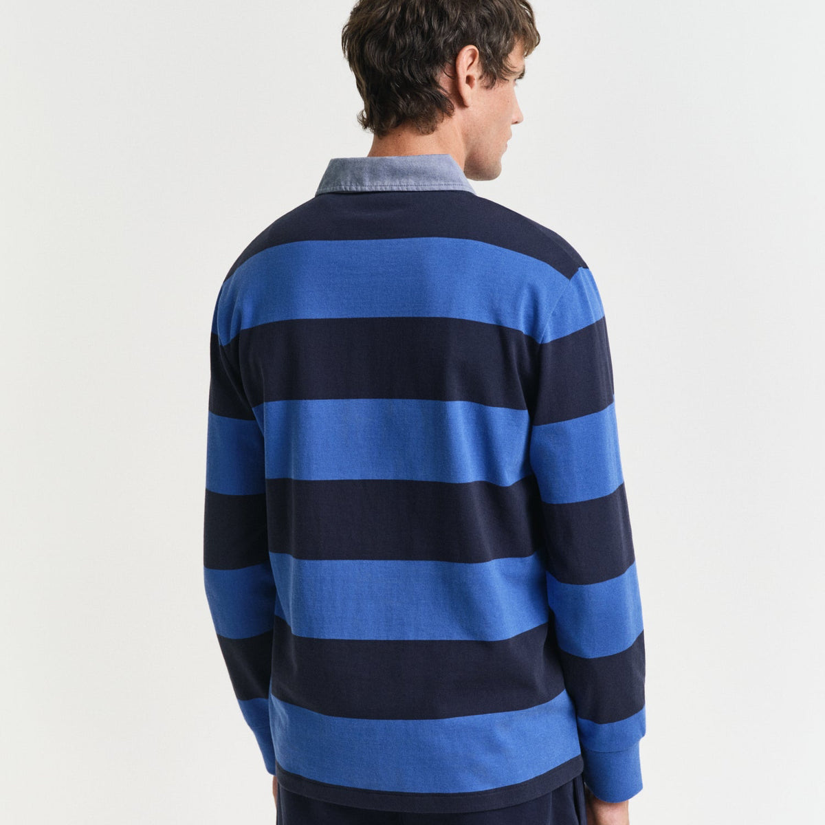 Person wearing a blue and navy striped sweater on a white background