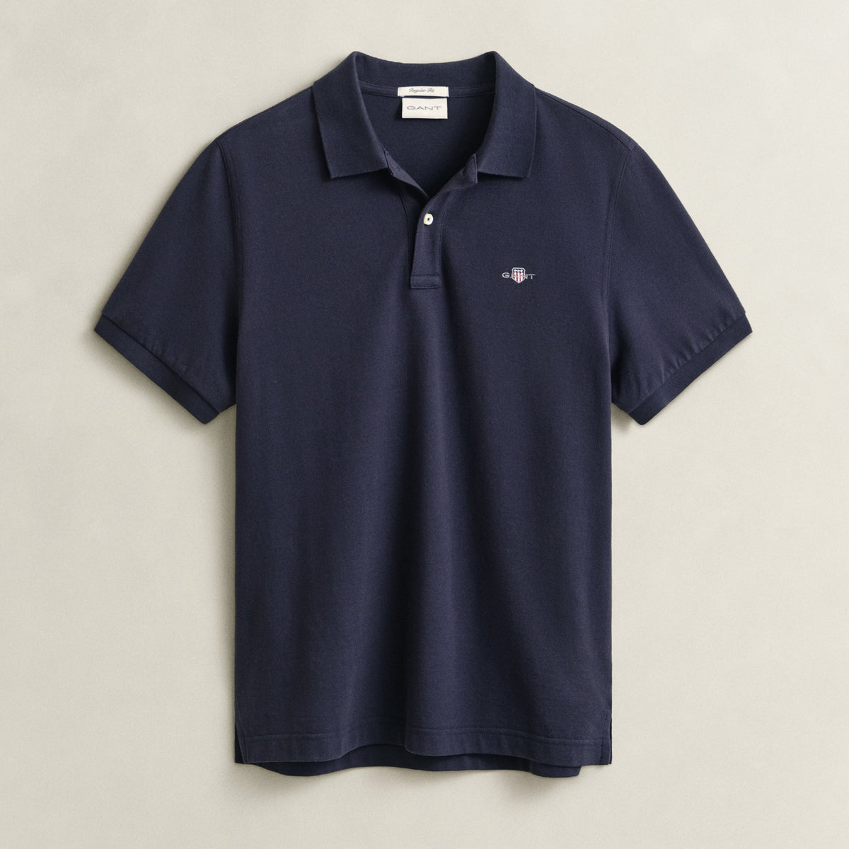 Navy blue polo shirt on a light beige background