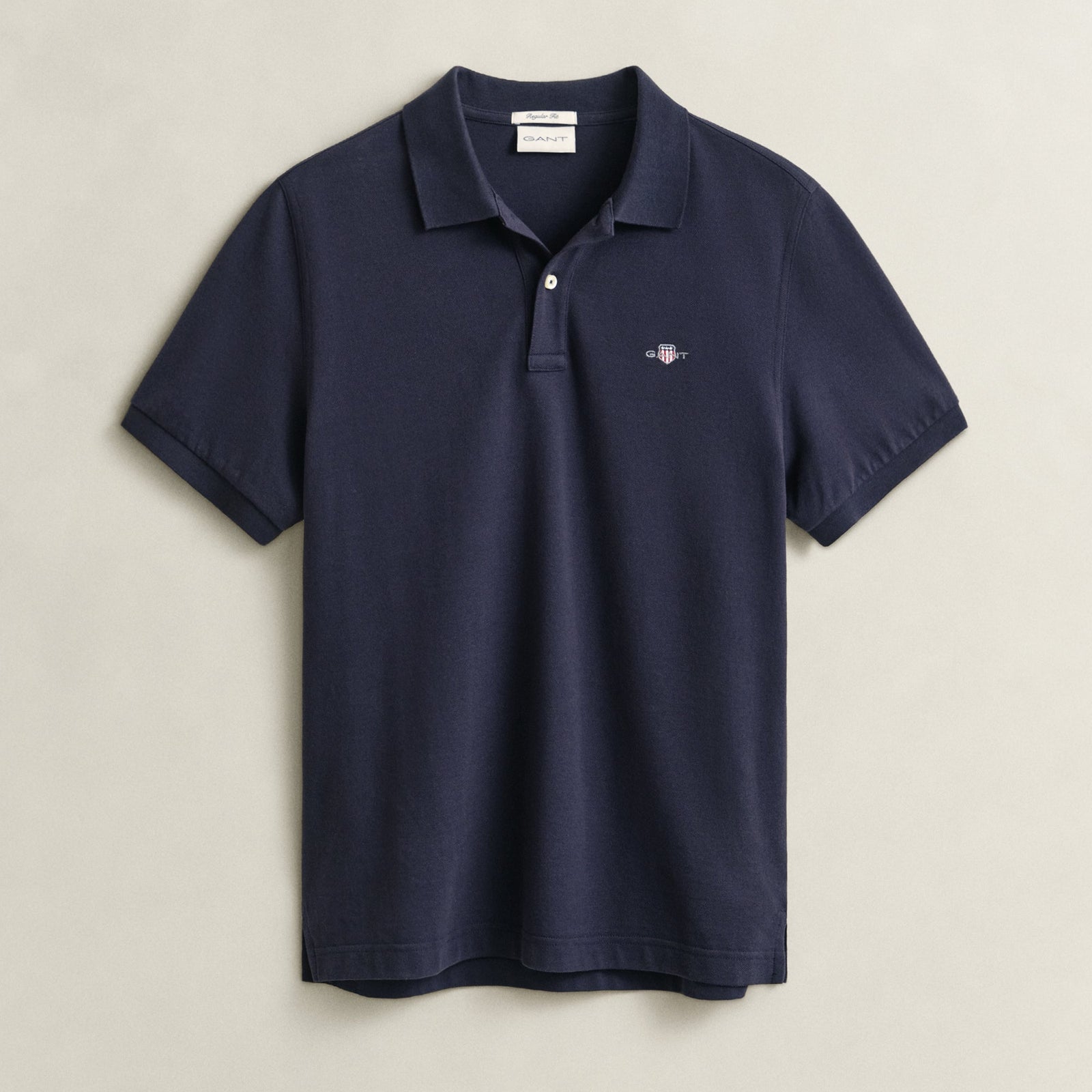 Navy blue polo shirt on a light beige background